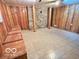 Partially finished basement space with wood paneling, decorative stone accent wall, and tile flooring at 5846 Bellsville Pike, Columbus, IN 47201