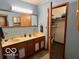 Bathroom featuring double sinks, a large mirror and view into walk-in closet at 5846 Bellsville Pike, Columbus, IN 47201