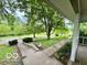 Inviting front yard featuring mature trees, stone steps, and a charming covered porch at 5846 Bellsville Pike, Columbus, IN 47201