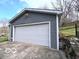 Spacious detached two car garage with a white door, complementing the house's architecture at 5846 Bellsville Pike, Columbus, IN 47201