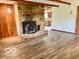 Cozy living room highlighting a stone fireplace, wood beam ceiling, and modern floors at 5846 Bellsville Pike, Columbus, IN 47201