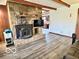 Living room with a stone fireplace, wood-look floors, and an open floor plan to the kitchen at 5846 Bellsville Pike, Columbus, IN 47201