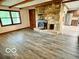Spacious living room featuring a stone fireplace, wood beam ceiling, and modern floors at 5846 Bellsville Pike, Columbus, IN 47201