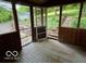 View of the screened porch with wood floors overlooking the landscaped yard at 5846 Bellsville Pike, Columbus, IN 47201