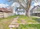 The backyard features lush grass and a detached garage behind a white house at 609 E Southern Ave, Indianapolis, IN 46203