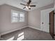 Cozy bedroom features a ceiling fan, neutral walls, and a large window at 609 E Southern Ave, Indianapolis, IN 46203