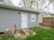 Home exterior featuring light gray siding, a white door, and lush green grass at 6189 Vigo Dr, Clayton, IN 46118