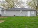 Home exterior featuring light gray siding, a new roof, a back door, and well-maintained lawn at 6189 Vigo Dr, Clayton, IN 46118