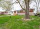 Red brick home with a well maintained lawn and a stone driveway near a large tree at 6189 Vigo Dr, Clayton, IN 46118
