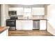 Bright, modern kitchen with white cabinets, wood counters, stainless steel appliances, and tile backsplash at 6189 Vigo Dr, Clayton, IN 46118