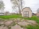 View of the backyard shows a shed, partially cracked concrete area, and a grassy area at 6189 Vigo Dr, Clayton, IN 46118