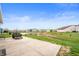 The backyard features a concrete patio, fire pit, and serene pond at 6323 Emerald Field Way, Indianapolis, IN 46221