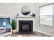 Close up of fireplace featuring dark stone, white mantle, a mirror and a houseplant at 6323 Emerald Field Way, Indianapolis, IN 46221