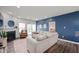 Bright living room with fireplace, neutral furniture, a blue accent wall and access to the home's exterior at 6323 Emerald Field Way, Indianapolis, IN 46221