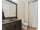 Bathroom featuring a dark vanity with mirror, toilet, and shower with beige curtains at 6841 W Glory Maple Dr, McCordsville, IN 46055