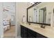 Bathroom featuring double sinks, dark cabinets, and bright lighting. Bedroom in background at 6841 W Glory Maple Dr, McCordsville, IN 46055