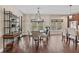Bright dining room featuring hardwood floors, modern chandelier, and large windows overlooking the backyard at 6841 W Glory Maple Dr, McCordsville, IN 46055