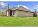 Brick home featuring an expansive lawn, covered patio, and manicured landscaping at 6841 W Glory Maple Dr, McCordsville, IN 46055
