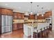 A well-lit kitchen featuring dark wood cabinets, granite countertops, and a central island with seating at 6841 W Glory Maple Dr, McCordsville, IN 46055