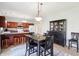 Open dining area features a china cabinet, modern light fixture, and flows into a kitchen with cherry cabinets at 7354 Ponderosa Pines Ln, Indianapolis, IN 46239