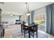 Open dining area features sliding glass doors, modern light fixture, and flows into a living room at 7354 Ponderosa Pines Ln, Indianapolis, IN 46239