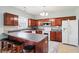 Kitchen featuring dark cherry cabinets, stainless steel microwave, and an island with seating for three at 7354 Ponderosa Pines Ln, Indianapolis, IN 46239