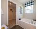 Bathroom featuring a soaking tub and a window with blue and white buffalo check valance at 7628 Big Bend Blvd, Camby, IN 46113