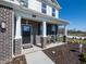 Inviting front porch with rocking chairs, brick columns, and a modern black front door at 7628 Big Bend Blvd, Camby, IN 46113