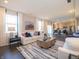 Bright living room with hardwood floors, white sofas, decorative pillows, and an open view to the kitchen at 7628 Big Bend Blvd, Camby, IN 46113