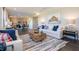 Open-concept living room flowing into the kitchen and dining area, featuring comfortable sofas and stylish decor at 7628 Big Bend Blvd, Camby, IN 46113