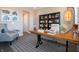 Bright home office with a wooden desk, wingback chair, and vintage camera decor at 7628 Big Bend Blvd, Camby, IN 46113