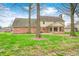 The yard is a well-maintained lawn, mature trees, and a partially bricked back exterior of the home at 7688 Gunsmith Ct, Plainfield, IN 46168