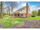 Back exterior view highlights brickwork, siding, a sunroom, and lush greenery at 7688 Gunsmith Ct, Plainfield, IN 46168