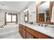 Bright bathroom features a soaking tub, dual sinks with marble counters and wooden cabinets at 7688 Gunsmith Ct, Plainfield, IN 46168