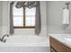 Soaking tub with window and soft light, features a tile surround and neutral colors at 7688 Gunsmith Ct, Plainfield, IN 46168