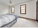 Bright bedroom with two windows, neutral carpeting, and a ceiling fan at 7688 Gunsmith Ct, Plainfield, IN 46168