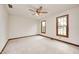 Bright, empty bedroom has neutral carpet, ceiling fan, and warm wooden window trim at 7688 Gunsmith Ct, Plainfield, IN 46168