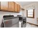 Bright laundry room with front-load washer and dryer, overhead cabinets, and neutral decor at 7688 Gunsmith Ct, Plainfield, IN 46168