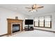 Bright living room with a brick fireplace, ceiling fan, and large windows with lace curtains at 7688 Gunsmith Ct, Plainfield, IN 46168