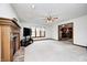 Bright living room with carpet, a brick fireplace, ceiling fan, and an open doorway to the kitchen at 7688 Gunsmith Ct, Plainfield, IN 46168