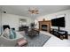 Cozy living room with a brick fireplace, ceiling fan, neutral furniture, and a large television at 7688 Gunsmith Ct, Plainfield, IN 46168