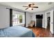 Comfortable bedroom featuring hardwood floors, a ceiling fan, and a bright window view at 902 Helm Dr, Avon, IN 46123