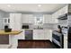 Well-lit kitchen featuring white cabinets, stainless steel appliances, and hardwood flooring at 902 Helm Dr, Avon, IN 46123