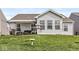 View of the back exterior, including a covered patio and well-maintained lawn at 9157 Tansel Crk Dr, Indianapolis, IN 46234