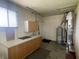 Utility room area with cabinetry, sink, and water heater for practical functionality at 9169 Hibben Ave, Indianapolis, IN 46229