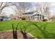 Expansive backyard with lush green grass and a charming two-story home with a sunroom at 9270 N Temple Ave, Indianapolis, IN 46240
