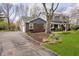 View of the home's exterior with attached garage and driveway, surrounded by mature trees at 9270 N Temple Ave, Indianapolis, IN 46240