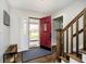 Inviting foyer with wood floors, staircase, and a bright red front door at 9270 N Temple Ave, Indianapolis, IN 46240
