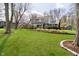 Well-maintained front yard with lush green lawn and mature trees surrounding the property at 9270 N Temple Ave, Indianapolis, IN 46240