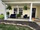 Inviting front porch with hanging plants, comfortable seating, and classic column supports at 9873 Blue Ridge Way, Indianapolis, IN 46234